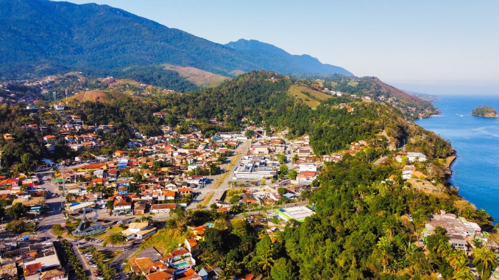 Vista aérea da cidade de Ilhabela entre o mar azul e as montanhas verdes