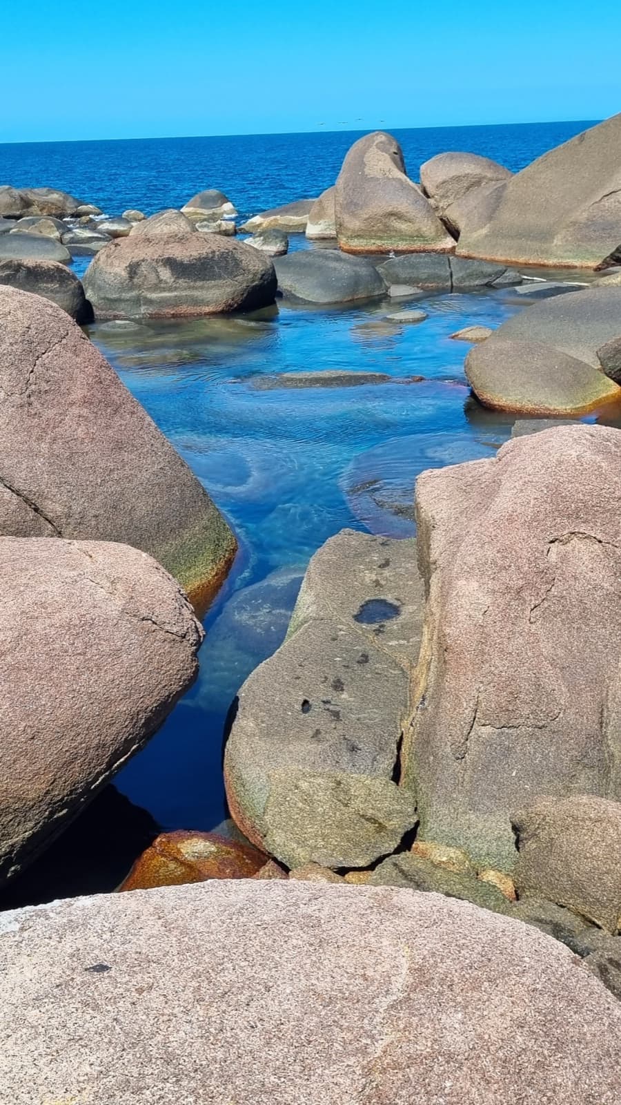 Piscinas naturais entre os matacões, com mar e céu azul intenso